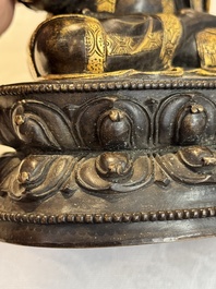A Tibetan parcel-gilt bronze sculpture of a lama, 20th C.