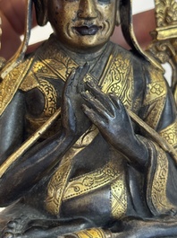 A Tibetan parcel-gilt bronze sculpture of a lama, 20th C.
