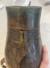 A Chinese archaic bronze inscribed wine vessel with scale design, 'hu 壺', Zhou