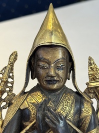 A Tibetan parcel-gilt bronze sculpture of a lama, 20th C.