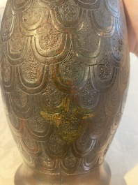 A Chinese archaic bronze inscribed wine vessel with scale design, 'hu 壺', Zhou