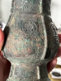 A Chinese archaic bronze food vessel and cover with taotie design, 'zhi 觶', Shang