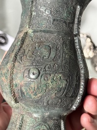 A Chinese archaic bronze food vessel and cover with taotie design, 'zhi 觶', Shang