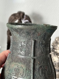 A Chinese archaic bronze food vessel and cover with taotie design, 'zhi 觶', Shang
