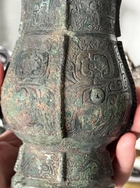 A Chinese archaic bronze food vessel and cover with taotie design, 'zhi 觶', Shang