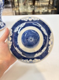 A pair of Chinese blue and white covered vases with floral design, 19th C.