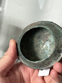 A Chinese archaic bronze food vessel and cover with taotie design, 'zhi 觶', Shang