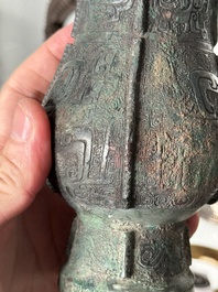 A Chinese archaic bronze food vessel and cover with taotie design, 'zhi 觶', Shang