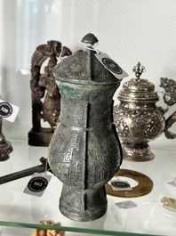A Chinese archaic bronze food vessel and cover with taotie design, 'zhi 觶', Shang