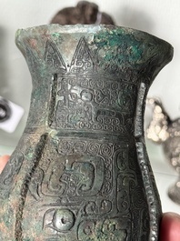A Chinese archaic bronze food vessel and cover with taotie design, 'zhi 觶', Shang