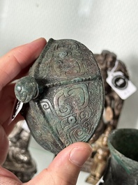 A Chinese archaic bronze food vessel and cover with taotie design, 'zhi 觶', Shang