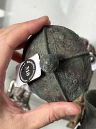 A Chinese archaic bronze food vessel and cover with taotie design, 'zhi 觶', Shang