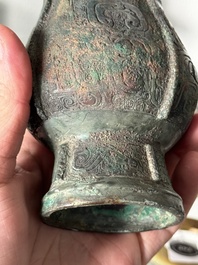 A Chinese archaic bronze food vessel and cover with taotie design, 'zhi 觶', Shang