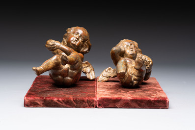 A pair of Flemish allegorical carved wood cherubs, 17th C.