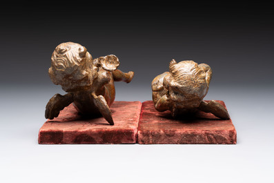 A pair of Flemish allegorical carved wood cherubs, 17th C.