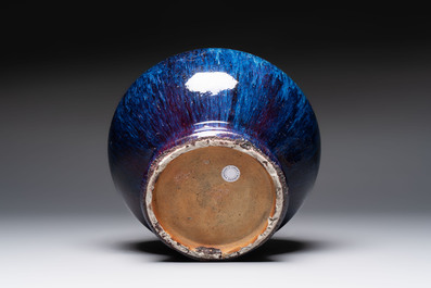 A Chinese flamb&eacute;-glazed vase on a wooden stand, 19th C.