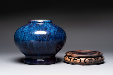 A Chinese flamb&eacute;-glazed vase on a wooden stand, 19th C.