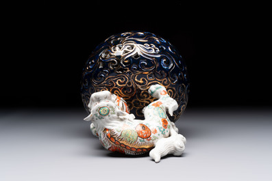 A Japanese Kutani group of a Shishi standing on an openworked brocade ball, 20th C.