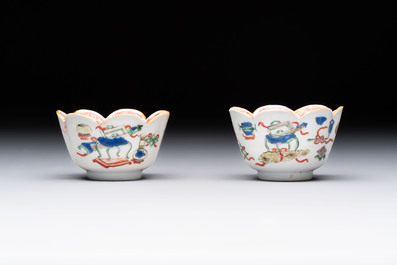 A pair of Chinese famille verte cups and saucers with antiquities, Kangxi