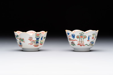 A pair of Chinese famille verte cups and saucers with antiquities, Kangxi