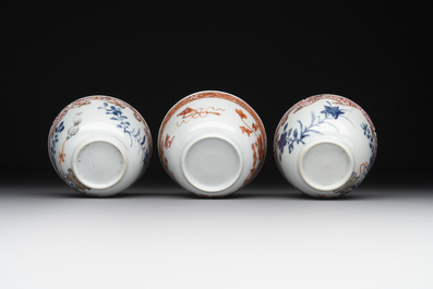 A pair of Chinese polychrome-decorated cups and saucers and an iron-red gilt-decorated cup and saucer, Yongzheng/Qianlong