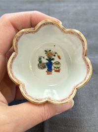A pair of Chinese famille verte cups and saucers with antiquities, Kangxi