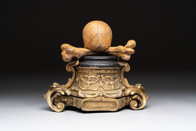 An Italian 'vanitas' or 'memento mori' skull with wooden crossbones on gilt-bronze base, 18/19th C.