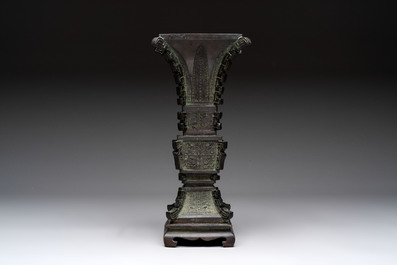 A Chinese archaistic bronze 'gu' vase and stand, Qing