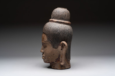 A Cambodian stone head of Shiva with braided hair and traces of gilt lacquer, Khmer Baphuon-style, 20th C.