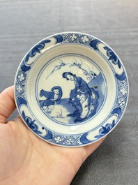 A pair of Chinese blue and white 'Elegant Beauty and Boy' cups and saucers, Chenghua mark, Kangxi
