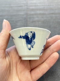 A pair of Chinese blue and white 'elegant beauty and boy' cups and saucers, Chenghua mark, Kangxi
