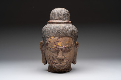 A Cambodian stone head of Shiva with braided hair and traces of gilt lacquer, Khmer Baphuon-style, 20th C.