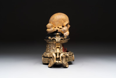 An Italian 'vanitas' or 'memento mori' skull with wooden crossbones on gilt-bronze base, 18/19th C.