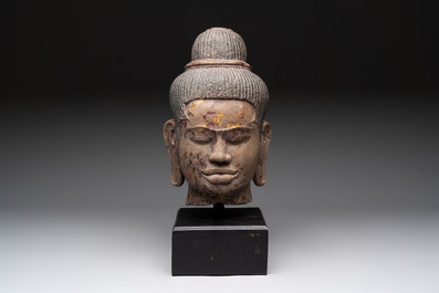 A Cambodian stone head of Shiva with braided hair and traces of gilt lacquer, Khmer Baphuon-style, 20th C.