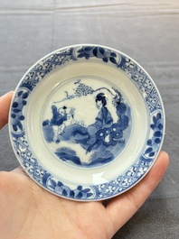A pair of Chinese blue and white 'elegant beauty and boy' cups and saucers, Chenghua mark, Kangxi