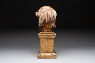 An Italian masked 'petrified' head on giltwood base, mixed media, 19/20th C.