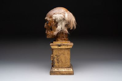 An Italian masked 'petrified' head on giltwood base, mixed media, 19/20th C.