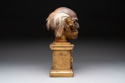 An Italian masked 'petrified' head on giltwood base, mixed media, 19/20th C.