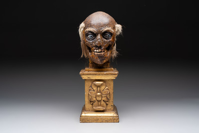 An Italian masked 'petrified' head on giltwood base, mixed media, 19/20th C.