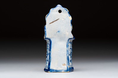 A blue and white Dutch Delft group of a child seated in a high chair, 18th C.
