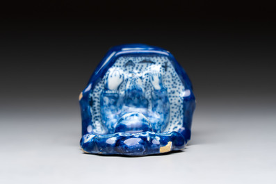 A blue and white Dutch Delft group of a child seated in a high chair, 18th C.