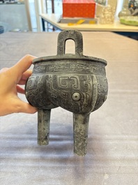 A Chinese archaic bronze tripod food vessel with 'taotie' design, 'ding 鼎', Western Zhou