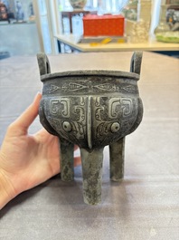 A Chinese archaic bronze tripod food vessel with 'taotie' design, 'ding 鼎', Western Zhou