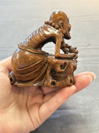 A Chinese fine huanghuali sculpture of a Luohan on a zitan stand, Qianlong mark, 19/20th C.