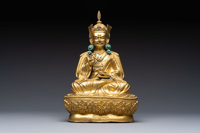 A Tibetan gilt-bronze figure of Padmasambhava holding a cup and a vajra, 17th C. or later