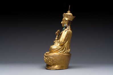 A Tibetan gilt-bronze figure of Padmasambhava holding a cup and a vajra, 17th C. or later