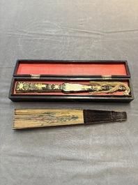 Two Chinese Canton gilt-lacquered and painted paper fans, one with its original box, 19th C.