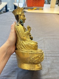 A Tibetan gilt-bronze figure of Padmasambhava holding a cup and a vajra, 17th C. or later
