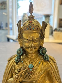 A Tibetan gilt-bronze figure of Padmasambhava holding a cup and a vajra, 17th C. or later