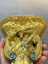 A Tibetan gilt-bronze figure of Padmasambhava holding a cup and a vajra, 17th C. or later